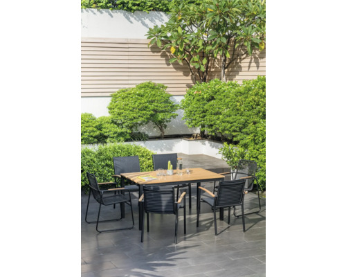 Scène de jardin avec une table à manger et des chaises entourées d'une végétation luxuriante