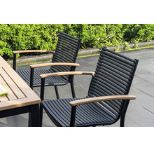 Deux chaises de jardin avec accoudoirs en bois et cadres en métal noir se trouvent à côté d'une table de jardin.