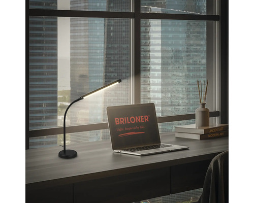 Schreibtisch mit LED-Tischleuchte, Laptop mit Briloner Logo, Büchern und Duftstäbchen