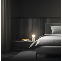 Schlafzimmer mit Bett, Nachttisch und Lampe