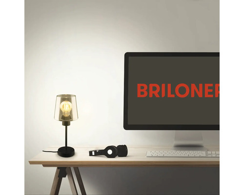 Szene mit einer Schreibtischlampe, Kopfhörern, einer Tastatur und einem Computermonitor.