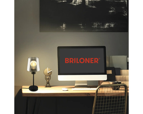 Tischleuchte auf einem Schreibtisch mit Computer und Dekoration