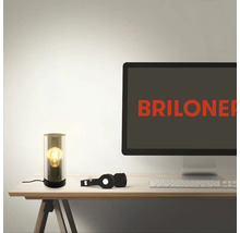 Tischleuchte auf einem Schreibtisch mit Computer und Kopfhörern