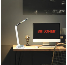 Schreibtisch mit Lampe, Computer und Dekorationsgegenständen für einen Arbeitsplatz