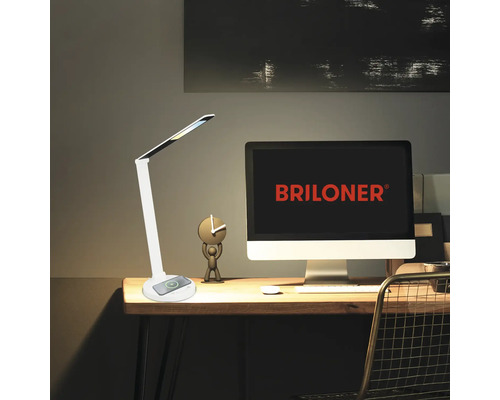 Schreibtisch mit Lampe, Computer und Dekorationsgegenständen für einen Arbeitsplatz