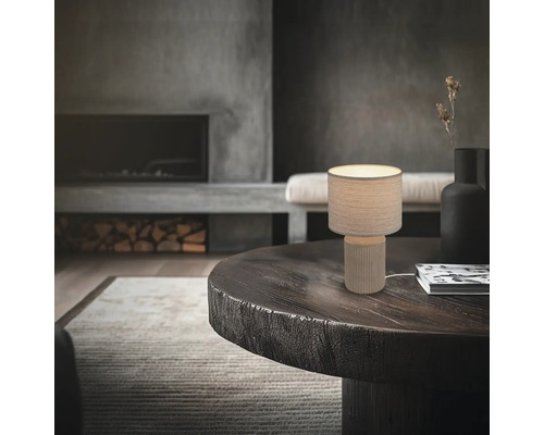 Dekorative Tischleuchte auf einem Tisch in einem Wohnzimmer mit Kamin.