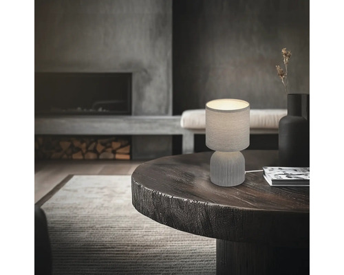 Tischleuchte auf einem runden Holztisch in einem Wohnzimmer