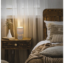 Schlafzimmer mit Nachttischlampe, Bett und Holzmöbeln