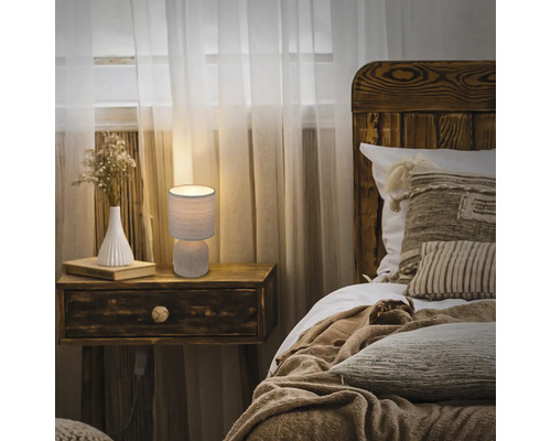 Schlafzimmer mit Nachttischlampe, Bett und Holzmöbeln