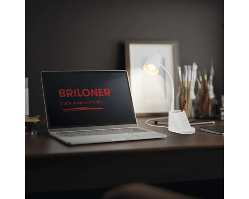 Szene mit einem Laptop mit dem Briloner Logo und einer weißen Schreibtischlampe.
