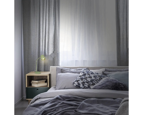 Schlafzimmer mit Bett, Nachttisch, Lampe und Vorhängen