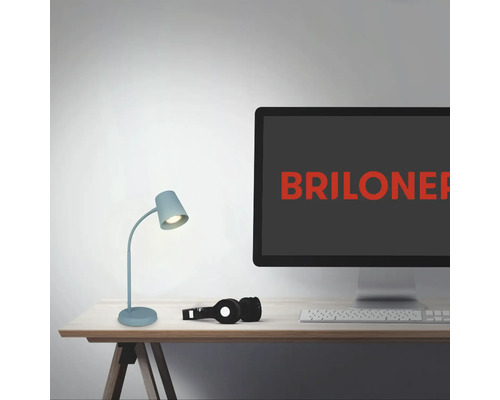 Szene mit Schreibtischlampe, Computer mit Briloner Logo, Kopfhörer und Tastatur