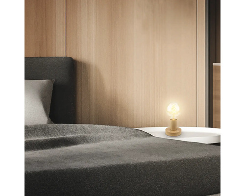 Nachttisch mit Lampe und Bett im Schlafzimmer