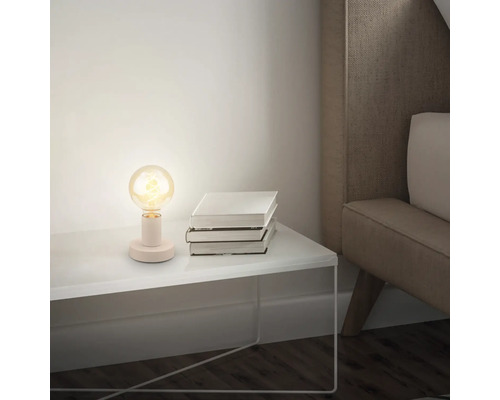 Dekorative Tischleuchte auf einem Nachttisch mit Büchern