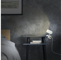 Szene mit Nachttisch, Büchern und einer Klemmleuchte