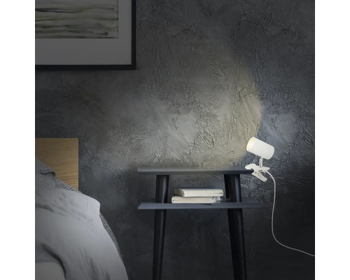 Szene mit Nachttisch, Büchern und einer Klemmleuchte