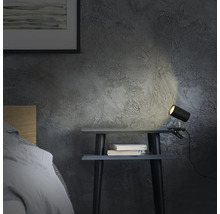 Nachttisch mit Klemmleuchte und zwei Büchern in einem Schlafzimmer