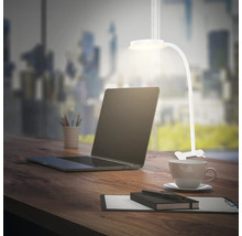 Schreibtisch mit Laptop, Schreibtischlampe, Notizblock, Stift und Kaffeetasse