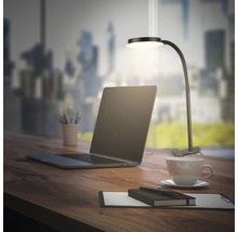 Schreibtisch mit Laptop, Tasse Kaffee, Notizblock und LED-Klemmleuchte