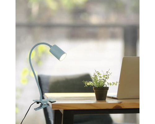 Klemmlampe auf einem Schreibtisch mit Laptop und Dekoration