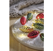 Weihnachtliche Szene mit Tannenzapfen-Christbaumschmuck und Lichterkette auf einem Teller mit Kunstschnee
