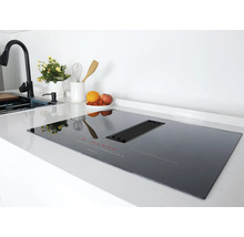 Schwarzes Induktionskochfeld mit Dunstabzugshaube auf einer Küchentheke