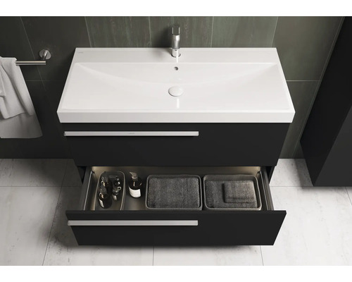 Meuble-lavabo avec tiroir ouvert, lavabo et robinet dans la salle de bain.
