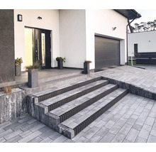 Extérieur d'une maison moderne avec une allée pavée et un escalier menant à l'entrée