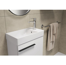Lavabo avec robinet, serviette et miroir dans la salle de bain