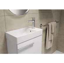 Meuble lavabo de salle de bain avec robinet, porte-serviettes et serviette.