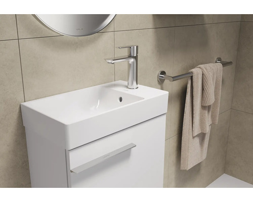 Meuble lavabo de salle de bain avec robinet, porte-serviettes et serviette.