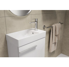 Salle de bains lumineuse avec meuble sous-lavabo, robinet et porte-serviettes