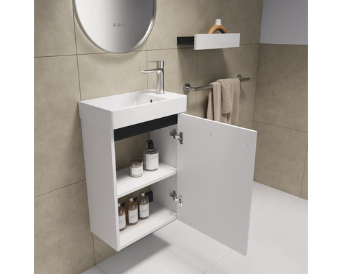 Meuble-lavabo avec armoire ouverte, lavabo, robinet, miroir, porte-serviettes et décoration