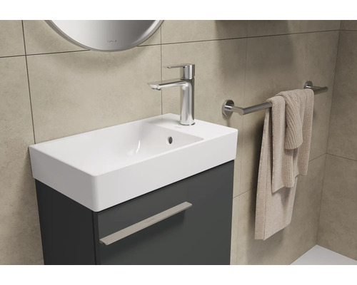 Lavabo de salle de bain avec meuble sous-vasque, robinetterie et porte-serviettes mural