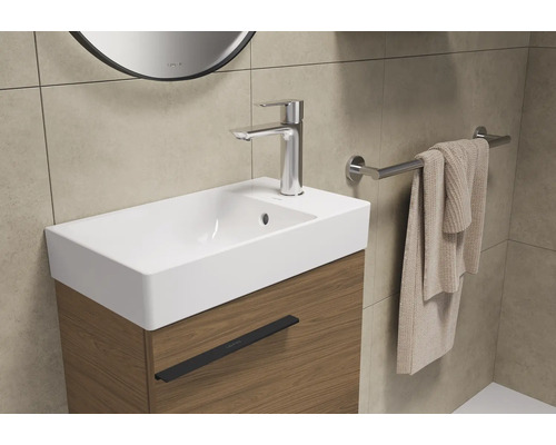 Lavabo avec meuble sous-vasque, robinet et porte-serviettes dans la salle de bain