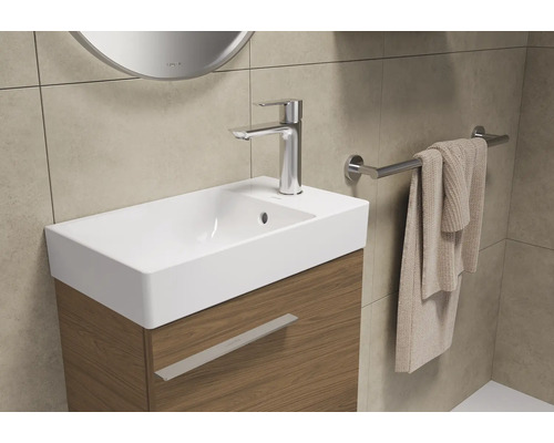 Meuble-lavabo de salle de bains avec robinet, serviette et porte-serviettes.
