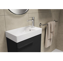 Lavabo avec robinetterie, serviette et miroir dans la salle de bain