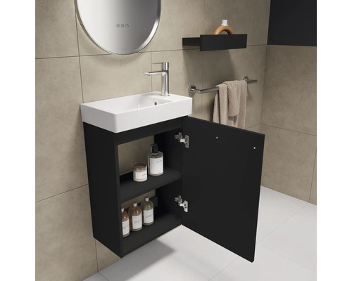 Salle de bains avec lavabo, meuble bas avec porte ouverte, étagère et miroir