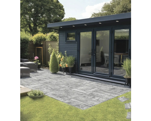 Gartenansicht mit Terrasse aus Betonpflastersteinen vor Gartenhaus