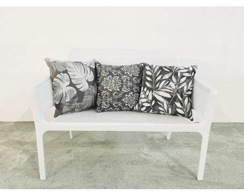 Weisses Sofa mit drei gemusterten Kissen