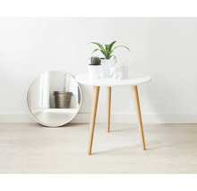 Dekorative Szene mit einem Spiegel, einem Tisch mit Pflanzen und einer Bärenfigur.