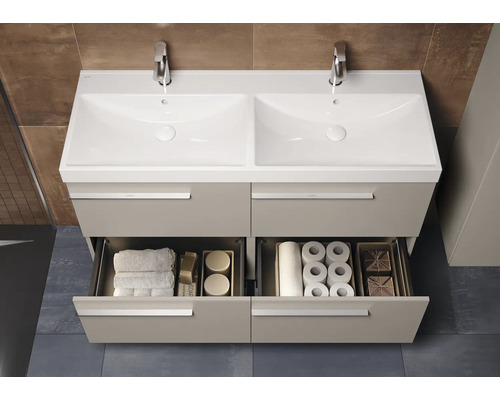 Meuble-lavabo avec deux vasques, robinetterie et tiroirs ouverts avec serviettes et papier toilette