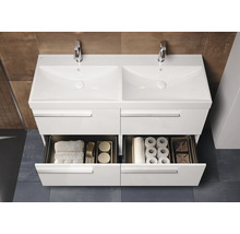 Meuble sous-lavabo blanc avec double vasque et tiroirs ouverts pour ranger les serviettes et le papier toilette.