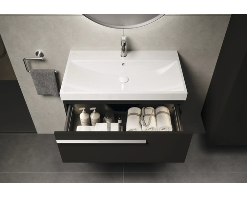 Lavabo avec tiroir ouvert, serviettes et accessoires de bain dans une salle de bain moderne