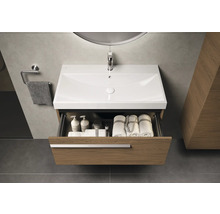 Meuble-lavabo avec tiroir ouvert dans la salle de bains, avec serviettes et produits de soin à l'intérieur