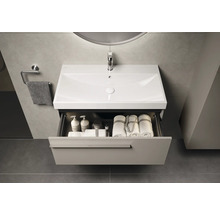 Lavabo de salle de bain moderne avec système de tiroirs ouverts pour ranger les serviettes et les produits de soins.