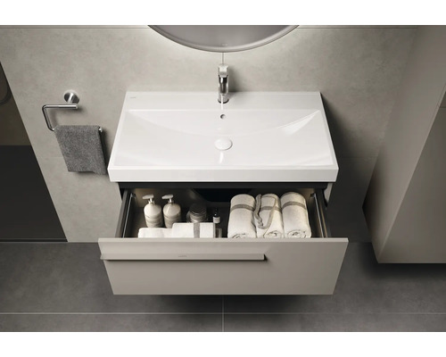Lavabo de salle de bain moderne avec système de tiroirs ouverts pour ranger les serviettes et les produits de soins.