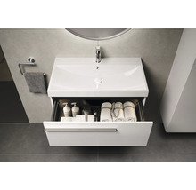 Meuble-lavabo avec tiroir ouvert, serviettes et produits de soins dans une salle de bain moderne