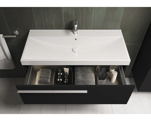 Meuble sous-lavabo avec tiroir ouvert, serviettes et articles de bain