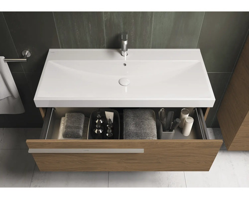 Salle de bain moderne avec meuble sous-lavabo, lavabo et tiroir ouvert pour serviettes et produits de soin